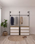 Glide Pipe Garment Rack wall-mounted, showcasing its industrial design and functionality for hanging clothing